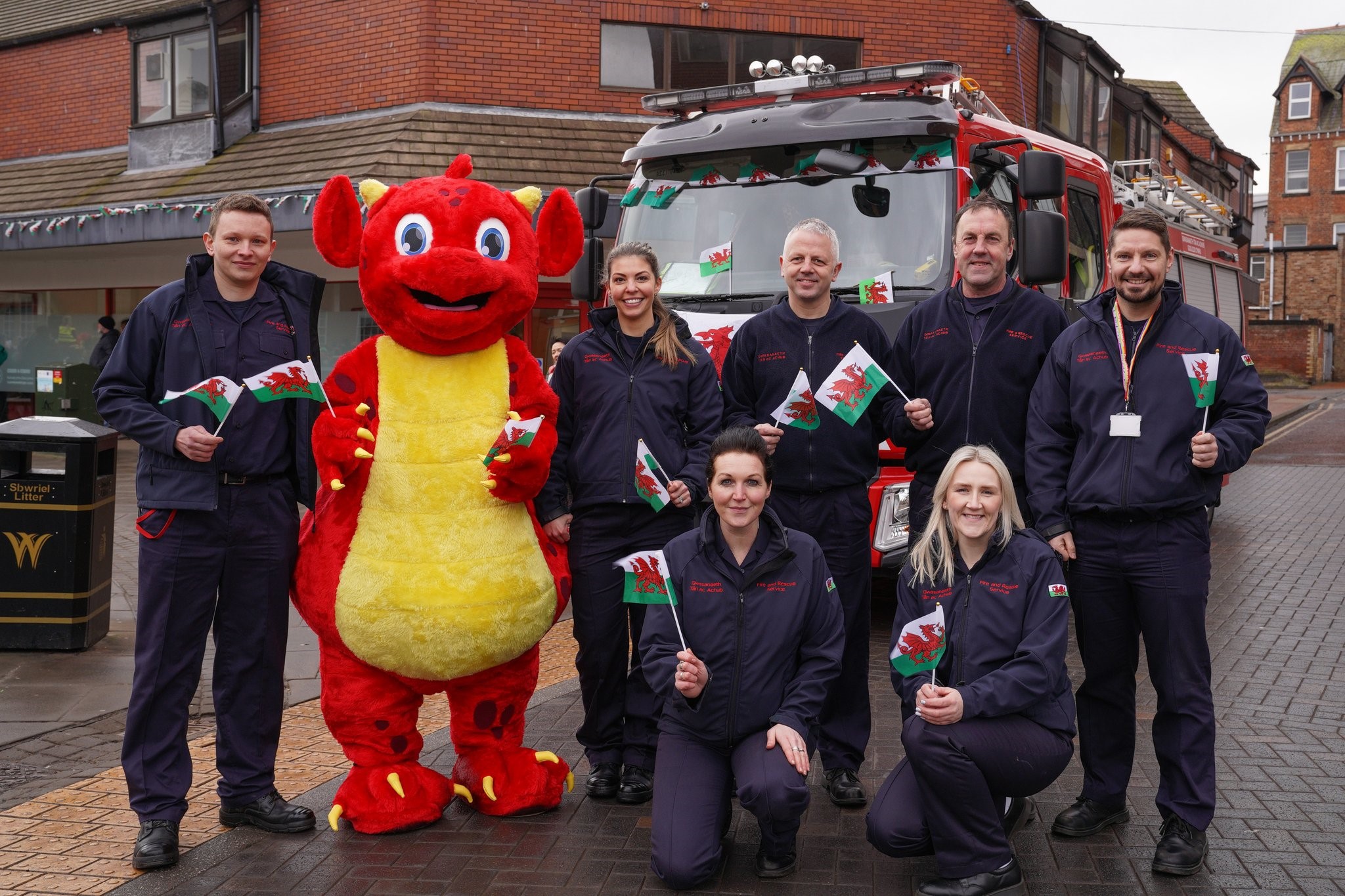 staff celebrating st David's Day with Sbarc the dragon costume and fire engine in the photo
